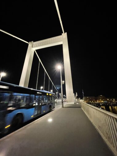 Bus Crosses Bridge at Night in Budapest